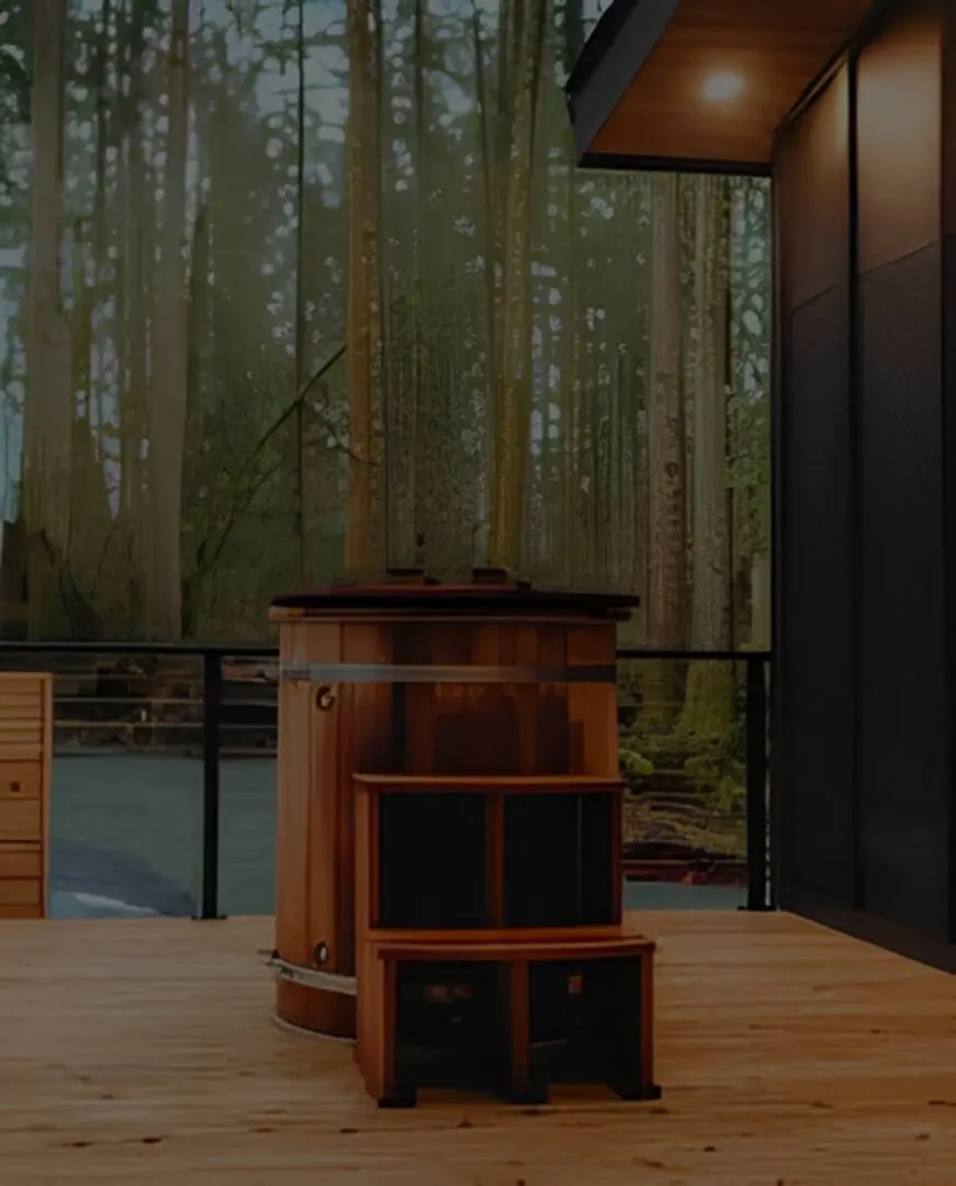 Cozy outdoor seating area with wooden furniture surrounded by tall trees.