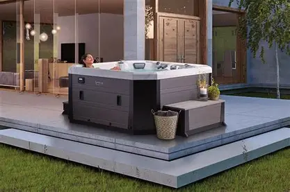 Modern outdoor hot tub with built-in seating and lighting.